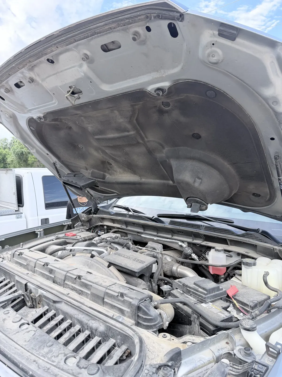 Dusty Duramax diesel engine bay on an HD pickup before engine bay detailing