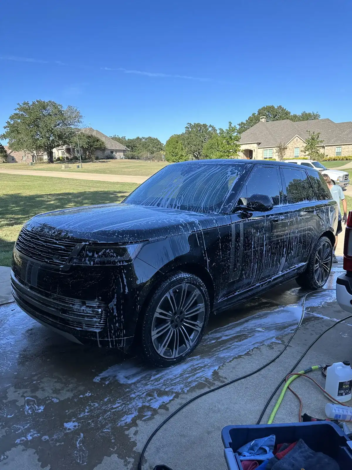 Foam hand wash in progress on a vehicle in a Kaufman County driveway
