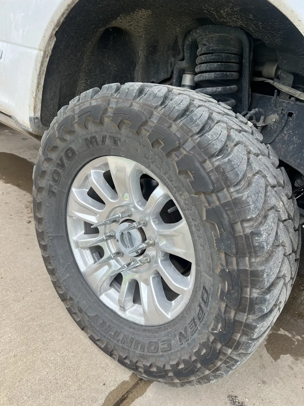 Mud-caked wheel and tire on a Ford F-250 Super Duty before detailing
