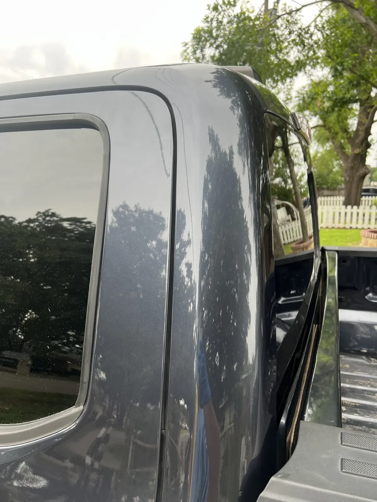 Same gray pickup cab pulled to a deep, swirl-free gloss after machine paint correction