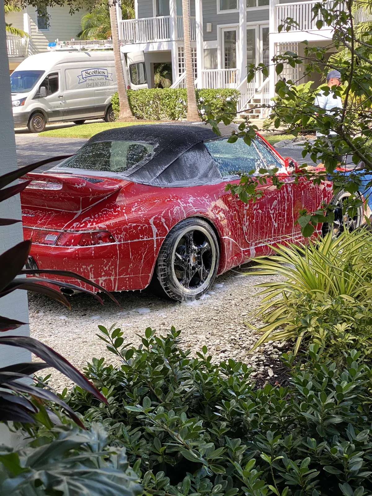 Red Porsche 911 993 cabriolet covered in foam during a mobile hand wash